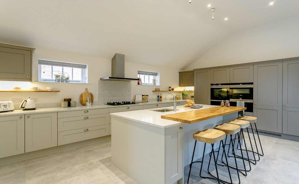 a large modular kitchen planned in gurgaon with corian countertop and dining area